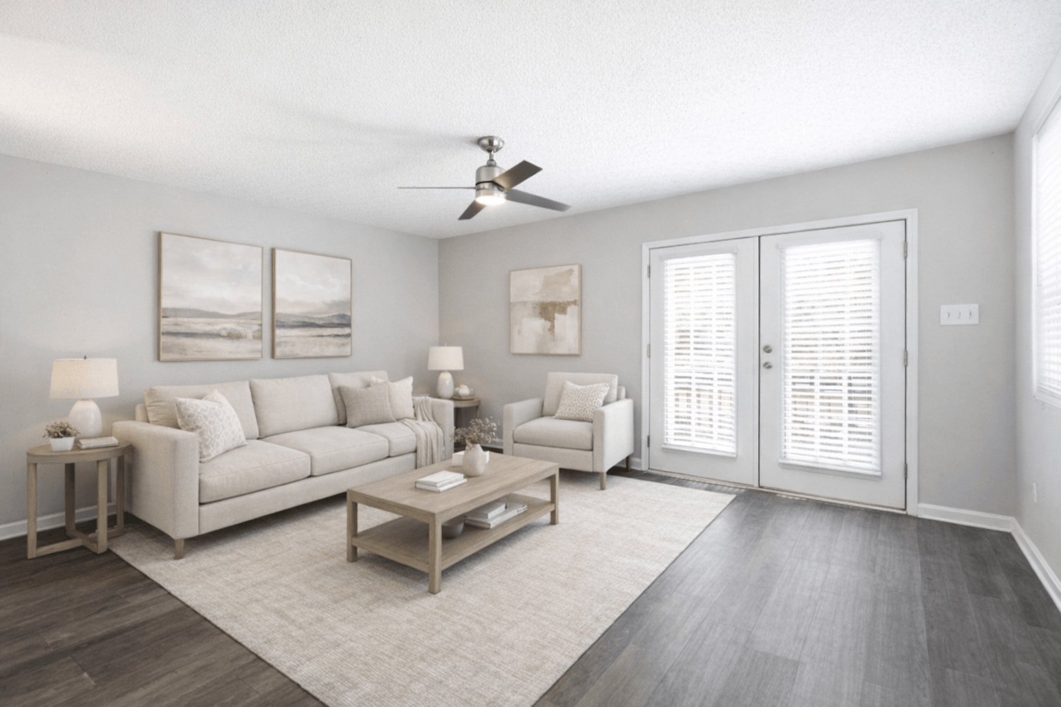 A living room with a white couch, a coffee table, and a ceiling fan.